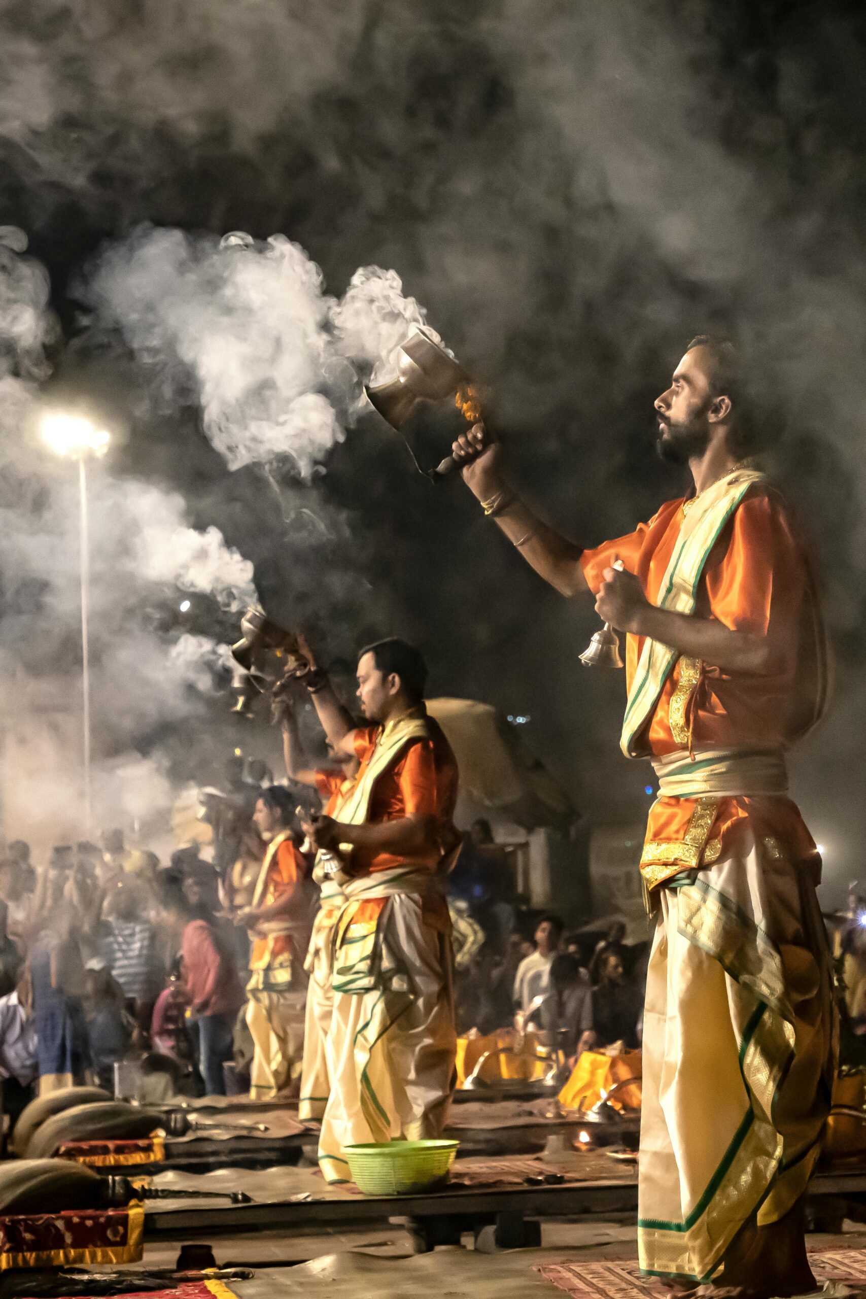 Indian priests perform Ganga Aarti at night in Varanasi, showcasing traditional rituals.